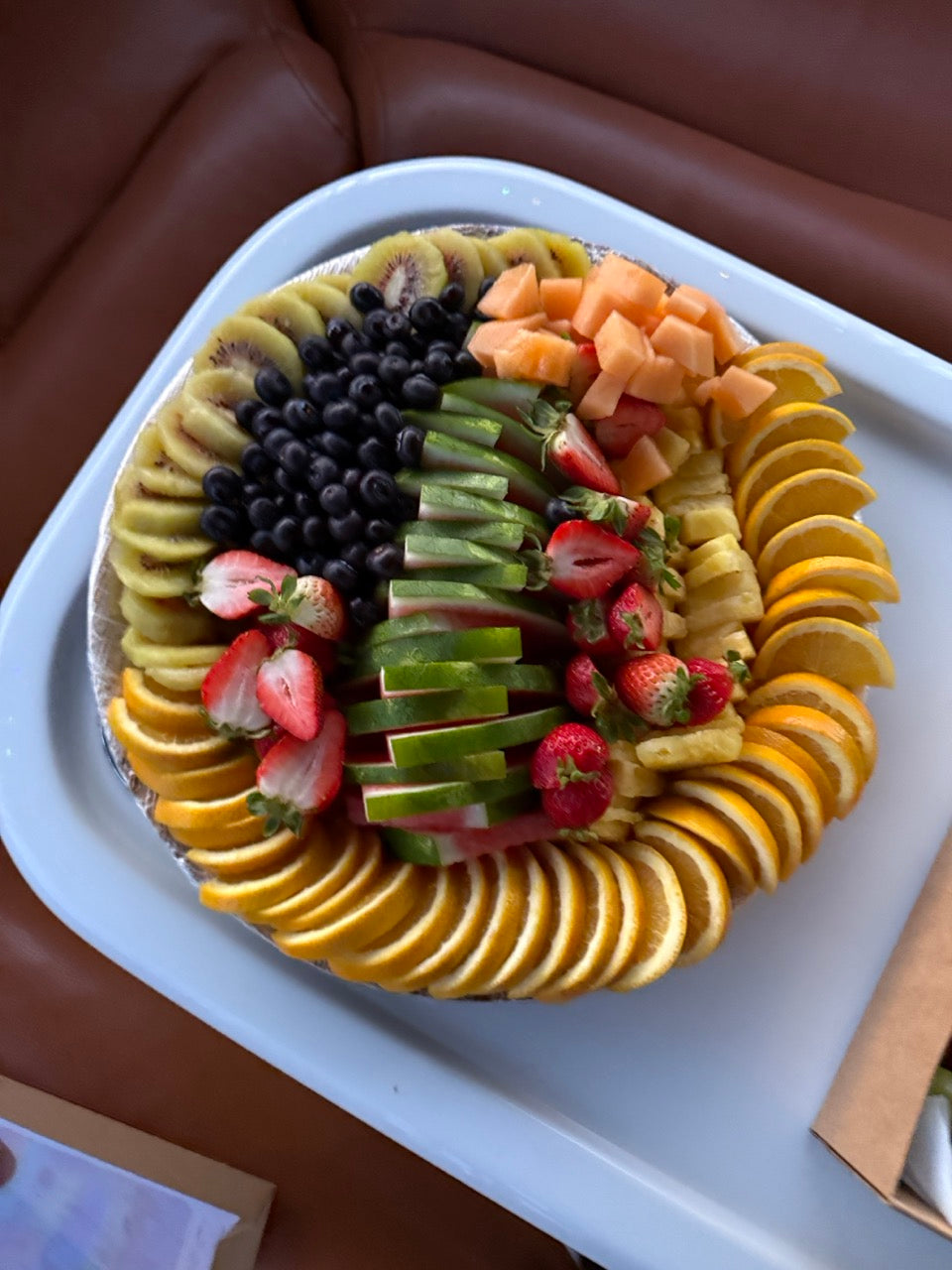 Colorful fruit platter on white tray with sliced kiwi, blueberries and strawberries for Newport Beach catering