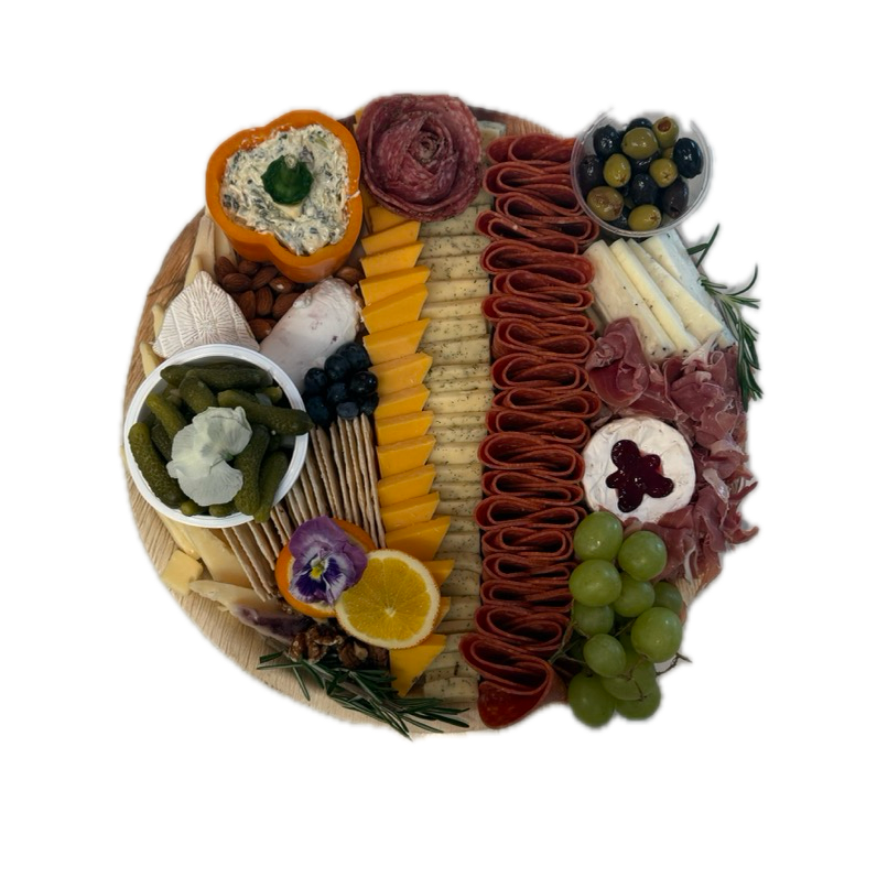 Gourmet charcuterie board on round wooden platter with sliced cheeses for Newport Beach catering