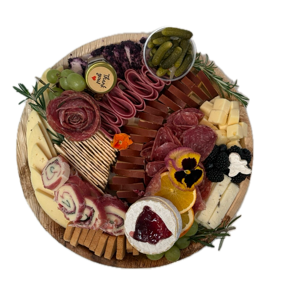 Beautifully arranged gourmet charcuterie board on round wooden platter for Orange County catering