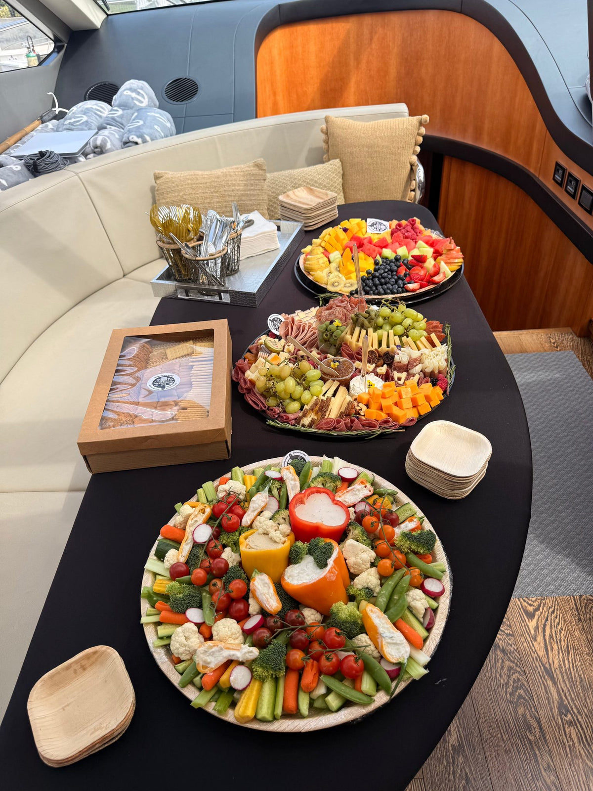 Large charcuterie and fruit board on black table inside yacht for Newport Beach delivery catering
